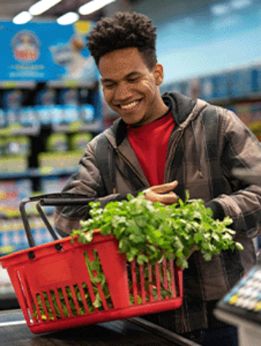 Man smiling while checking out groceries.