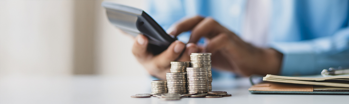 coins on a desk with calculator in the background