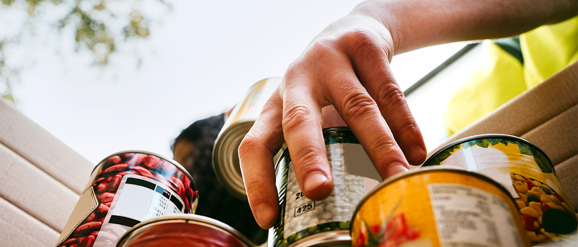 woman with grey hair stands over counter looking through bag of food