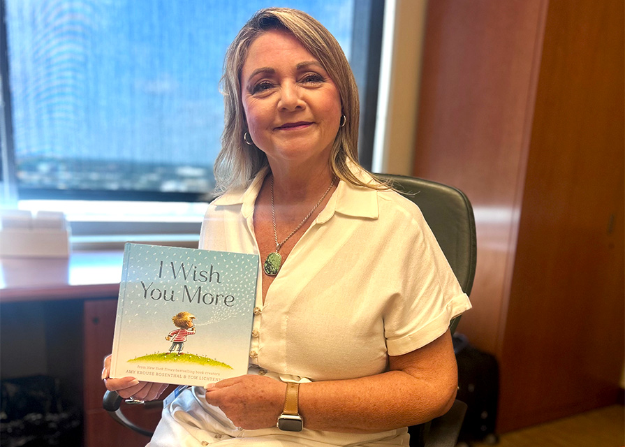 VP of Texas Plan Operations Patty Escoe holds a children’s book