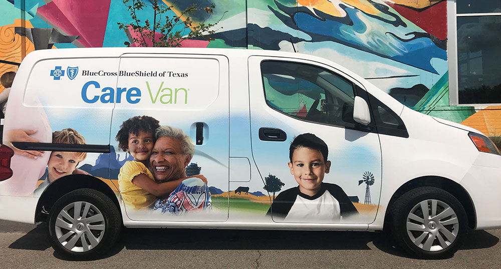 A Texas Care Van is shown in front of a building mural. 