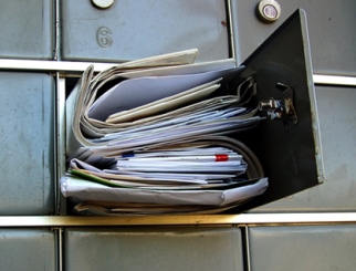 An open Post Office box full of mail