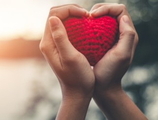 Hands holding a crochet heart