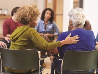 Personas presentes en la reunión de un grupo de terapia de autoayuda en un centro comunitario.