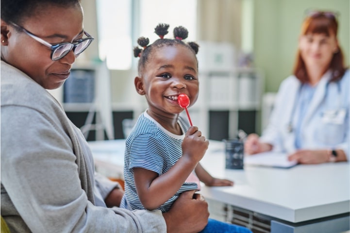 Smiling child sitting on parent's lap in the doctor's office