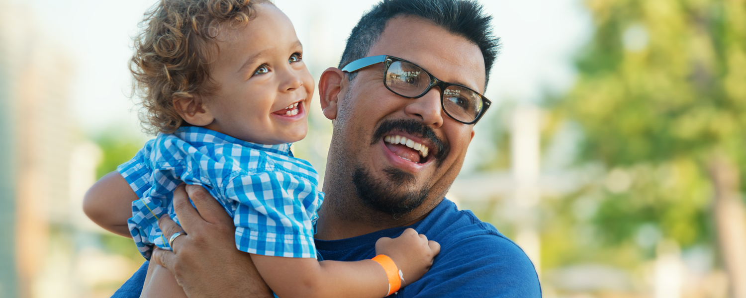 A father smiles while holding his child