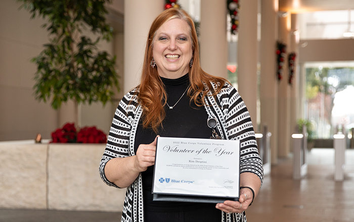 BCBSTX Volunteer of the Year Kim Droptini displays an award certificate.  