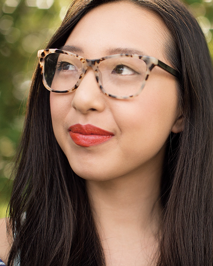 Woman wearing glasses gazes into the distance. 