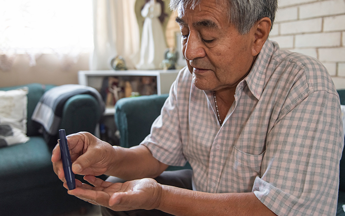 Elderly man checking his blood sugar