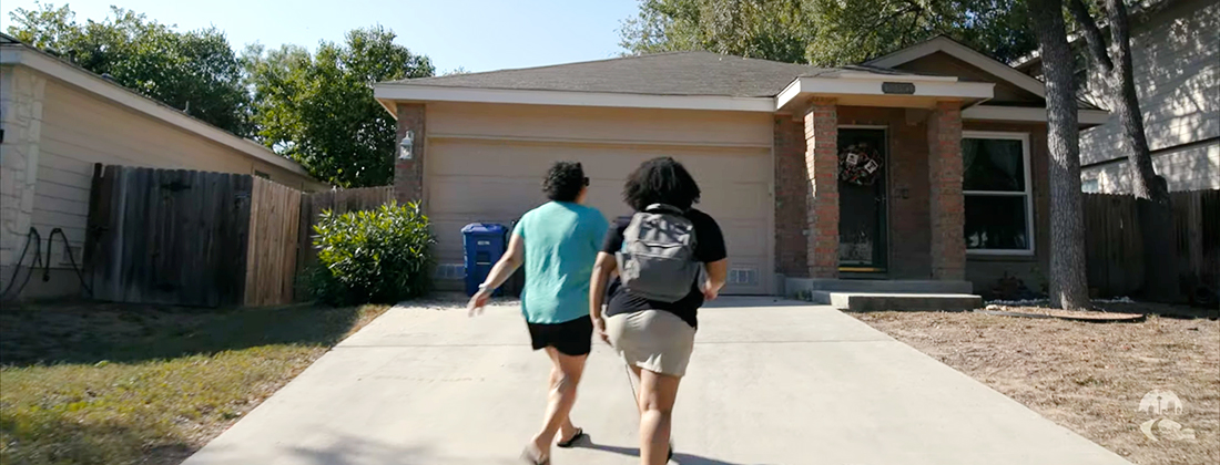 Two women walk up the driveway to their home