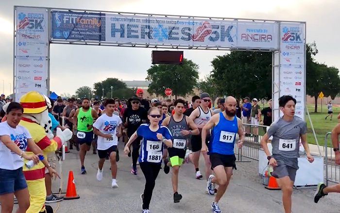 Runners passing though starting line at race