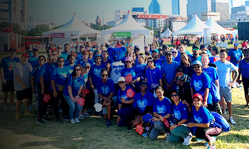 Empleados de BCBSTX posan para una foto grupal en un evento al aire libre