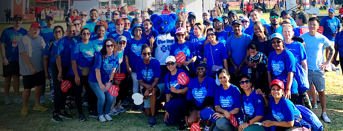 Empleados de BCBSTX posan para una foto grupal en un evento al aire libre