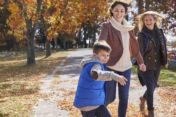 Family walking through the park in fall