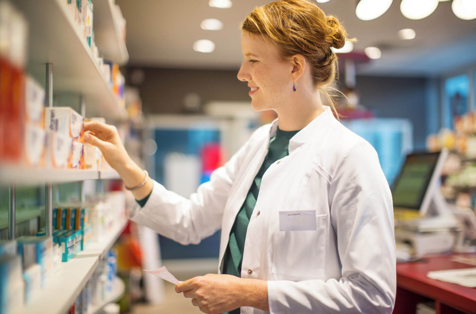 Smiling pharmacist handing out prescription